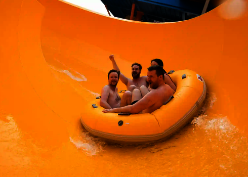 Vier Personen in einem großen Rutschreifen in einer gelben RR2700.