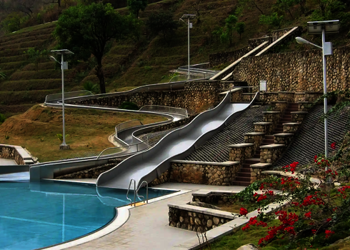 Eine Breitwellenrutsche und eine weitere Wasserrutsche, die einen Hang hinablaufen.