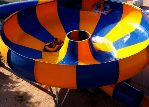 Mehrere Personen rutschen in einer blau-gelben Raft Bowl Wasserrutsche auf Rutschreifen.