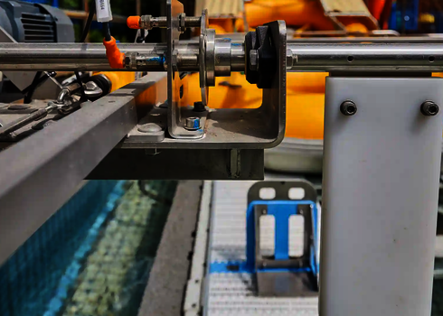 Detailed view of the raft conveyor technology with axles, pipes, and metal frame.