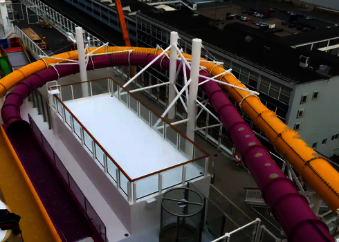 Zwei nebeneinander verlaufende RR900-Rutschen in Pink und Gelb auf einem Schiff.