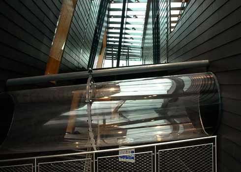 Innenansicht einer Wasserrutsche mit Acryl-Element, aufgehängt in moderner Architektur.