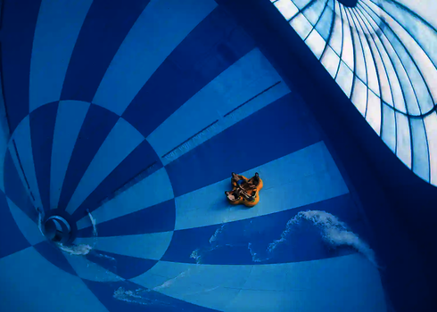 Innenansicht des Cyclone mit gelbem Boot auf blau-weiß gestreifter Rutschfläche.