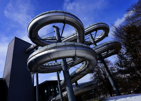 Große WR1040-Rutsche mit mehreren Spiralen neben einem modernen Gebäude im Winter.