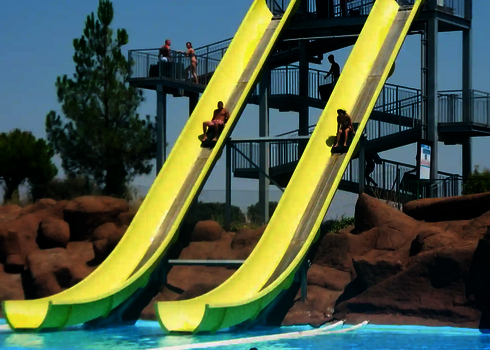 Personen rutschen auf zwei parallel laufenden Bahnen der Aqua Shuttle Wasserrutsche.
