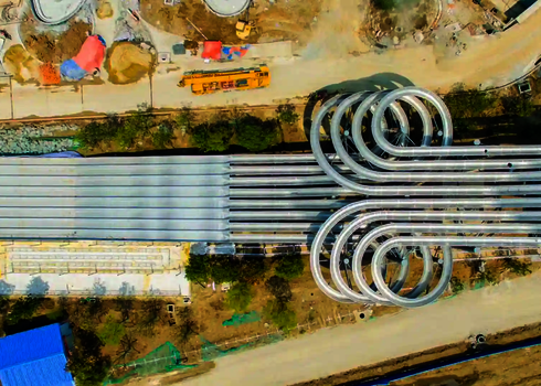 Luftaufnahme der Wasserrutsche Matracer mit sechs parallel geschwungenen Edelstahlbahnen.