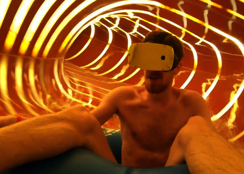 Mann rutscht mit VR-Brille durch die Family Twister Wasserrutsche mit Tageslichteffekten.