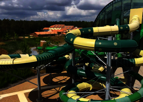 Blick auf eine große Rutschenanlage mit  einer RR1400 Wasserrutsche außerhalb eines Schwimmbads.