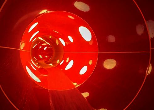 Innenansicht einer roten Wasserrutsche mit gepunkteten Tageslichteffekten.