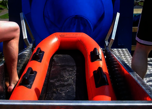 Rot-schwarzes Boot im Startbereich einer blauen Harakiri-Freizeitparkrrutsche.