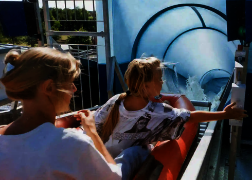 Zwei Personen sitzen im Boot und drücken auf den Startknopf für die Harakiri Wasserrutsche.