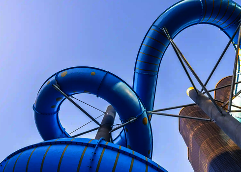 Sicht von unten auf eine blaue Outdoor-Wasserrutsche mit Lichteffekten.