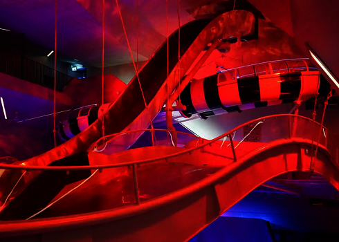 Innenansicht der Boomerang-Rutsche mit markanten Kurven und LED-Beleuchtung in Rot.