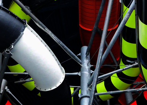  Verschlungene Röhrenrutschen in gelb-schwarz, rot und weiß aus der Froschperspektive.