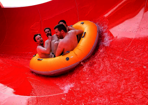 Mehrere Personen sitzen in einem gelben Reifen in einer roten RR2700.