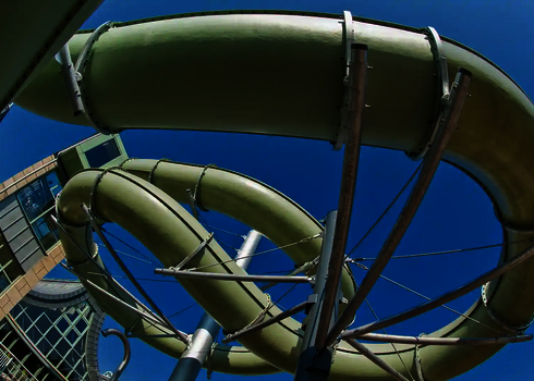 Sicht von unten auf eine grüne Wasserrutsche.