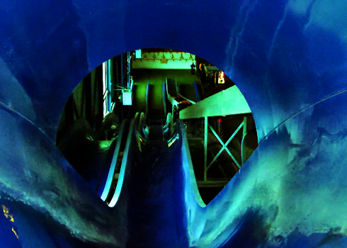 Blick aus einer blauen Wasserrutsche herunter ins Landebecken.