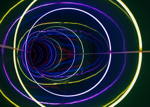 Innenansicht einer Röhrenrutsche mit LED-Ringen in Weiß, Gelb und Violett.