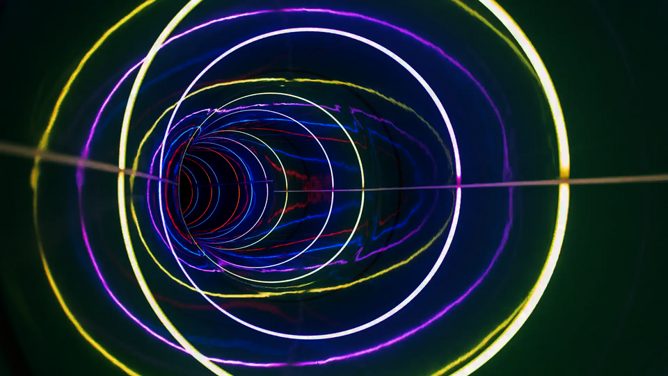 Innenansicht einer Röhrenrutsche mit LED-Ringen in Weiß, Gelb und Violett.