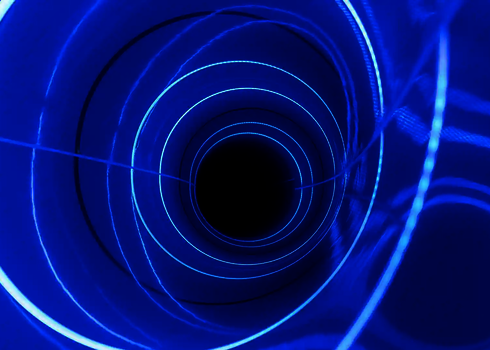 Innenansicht einer Röhrenrutsche mit blauen LED-Ringen und dunklem Tunnelende.