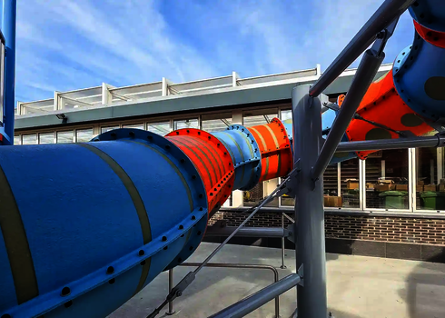 Blaue-orangene RR900-Kids getragen von Stützen aus Stahl.