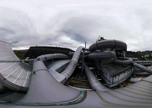 Übersicht eines weitläufigen Boomerang-Rutschenkomplexes auf einem Gebäudedach.