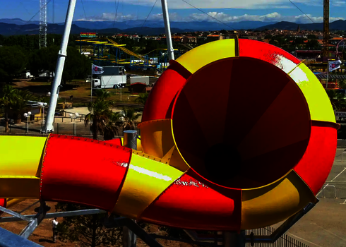 Blick auf den Crazy Cone Trichter von oben mit buntem Freizeitpark im Hintergrund.