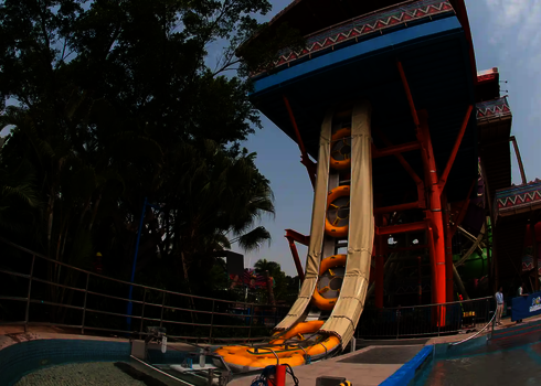 A vertical raft conveyor transports several large slide rafts upwards to the slide platform.