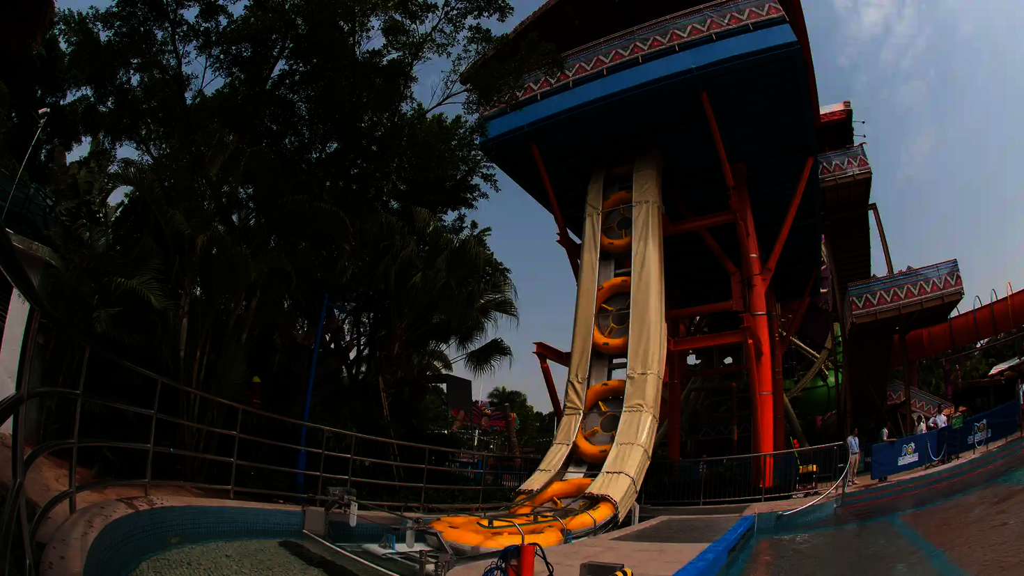 A vertical raft conveyor transports several large slide rafts upwards to the slide platform.