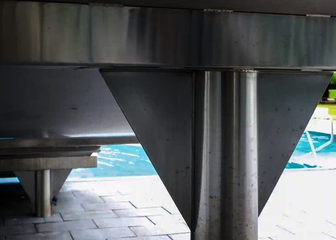 Blick auf einen Stahlpfosten, der sich vor einem Schwimmbecken befindet.