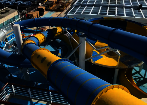 Verschlungene RR900-Rutschen in Blau und Gelb mit einer Body Bowl auf einem Kreuzfahrtschiff.