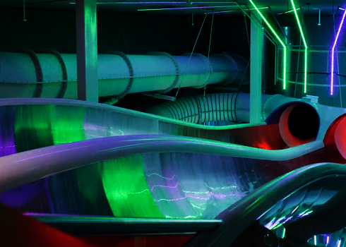 Grüne und pinke LED-Beleuchtung am Start der Raft Racer Reifenrutsche mit Wasserzufluss.