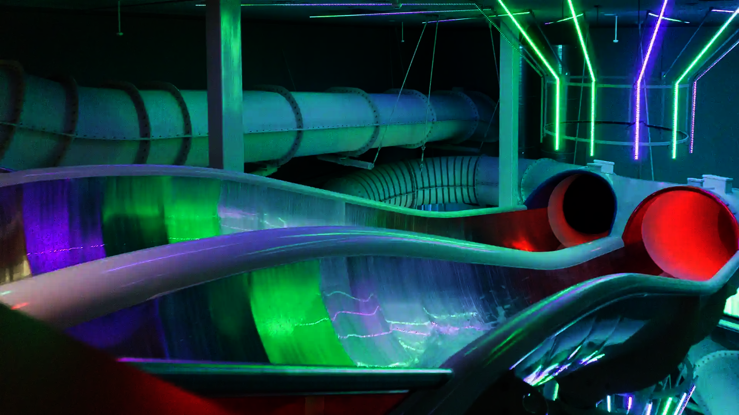 Grüne und pinke LED-Beleuchtung am Start der Raft Racer Reifenrutsche mit Wasserzufluss.