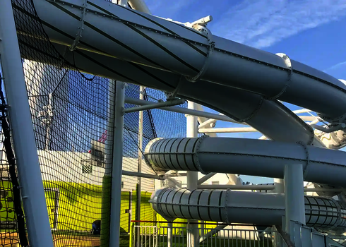 Weiße Wasserrutsche des Typs RR900 mit Netzsicherung auf einem Außendeck.