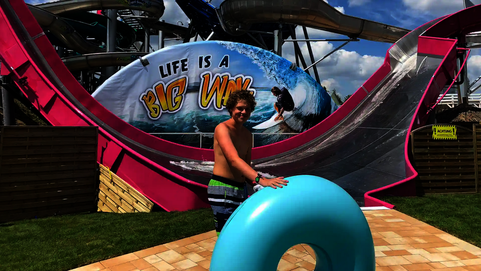 Ein Junge mit Reifen steht vor der pinken Sidewinder mit „Big Wave“-Grafik in der Galaxy Erding.