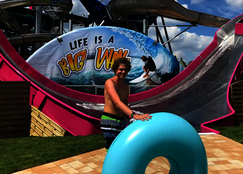 Ein Junge mit Reifen steht vor der pinken Sidewinder mit „Big Wave“-Grafik in der Galaxy Erding.