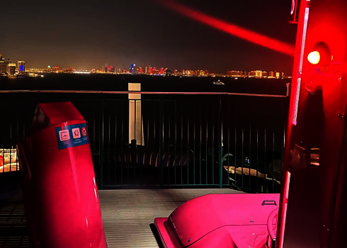 Zwei pinke U-Drop-Kapseln mit rotem Licht, im Hintergrund eine beleuchtete Skyline.
