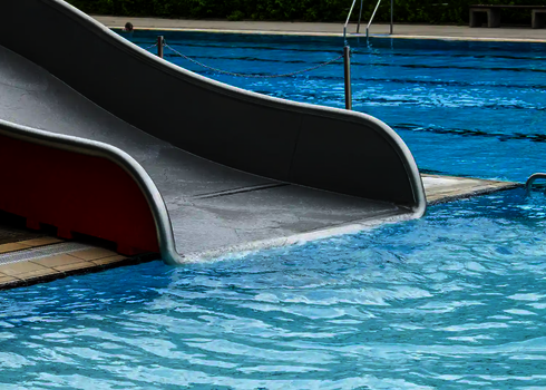 Das Ende einer Breitwellenrutsche, das sich in einem Schwimmbecken befindet.