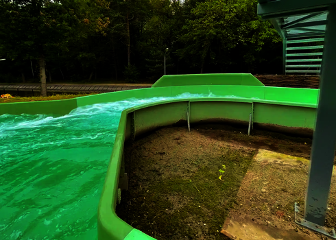 Grüner Wildwasserfluss mit geschwungenem Verlauf im Außenbereich .