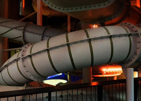 Weiße Wasserrutsche mit Tageslichteffekten, umgeben von Stützen & Stahl.