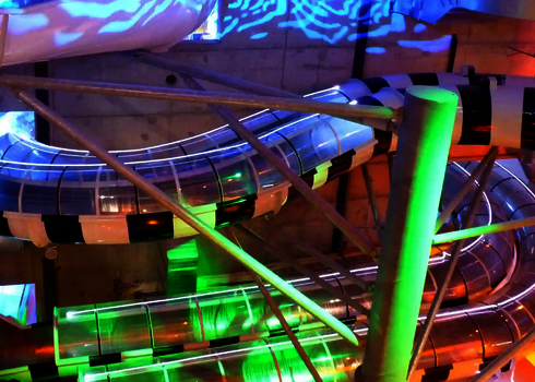 Beleuchtete Wasserrutsche mit transparenten Acryl-Elementen und Farblichteffekten im Kokpunkten Actionbad.
