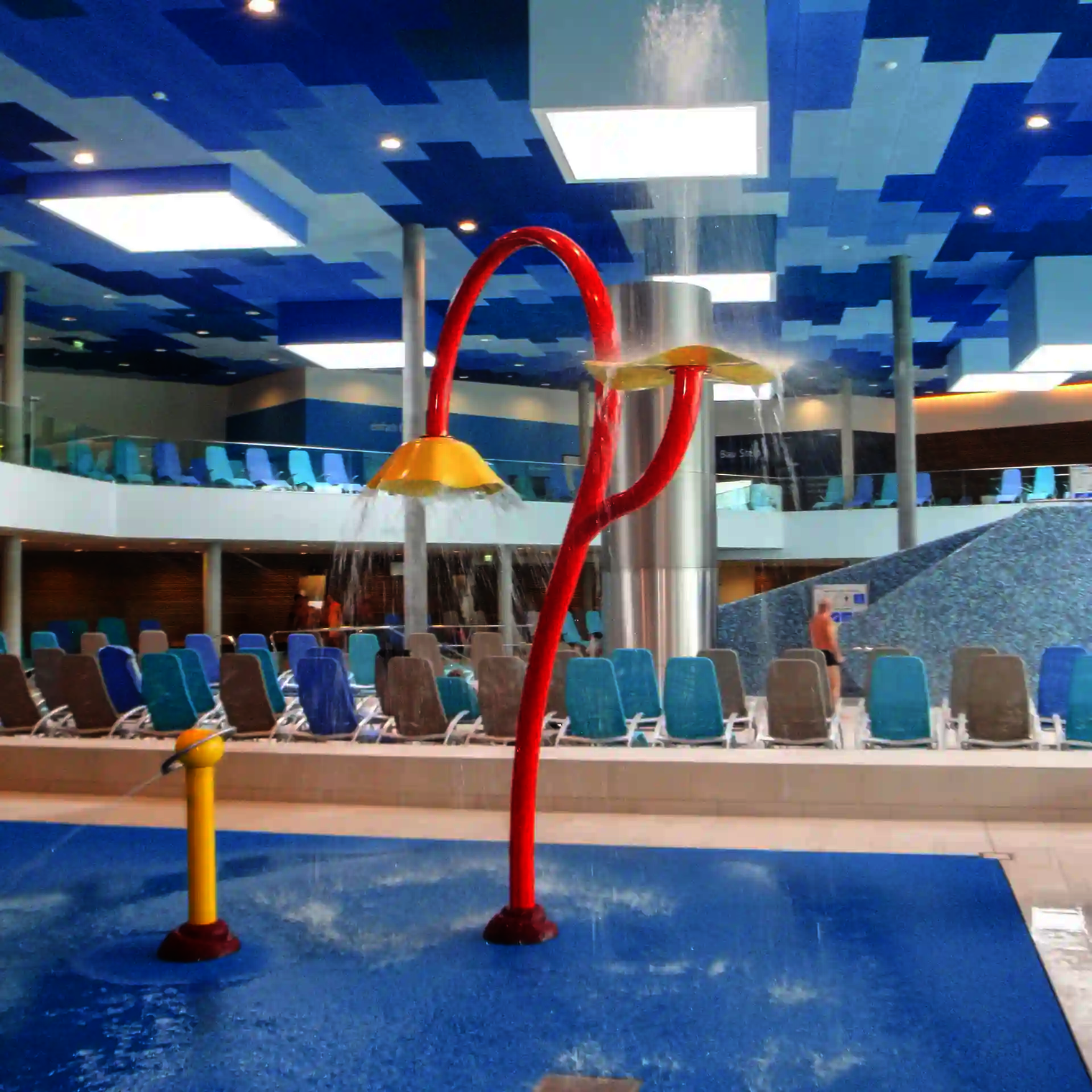 Wie-Spray Element "Blume" im blauen Innenbereich eines Schwimmbades.