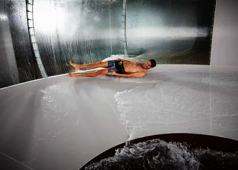 Innenansicht einer weißen Body Bowl mit einem rutschenden Mann in Badehose.