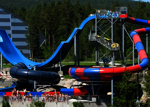 Blick auf den Outdoorbereich eines Wasserparks mit Boomerang, Raft Bowl und im Hintergrund Treppenaufgang. 
