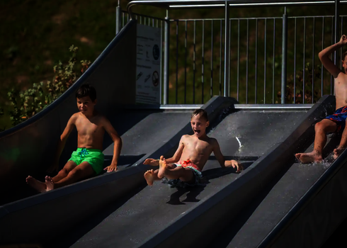 Drei Jungs starten gleichzeitig von oben auf der Trio-Slide.