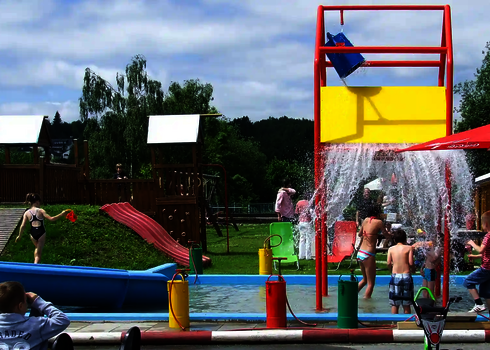 Wasserspielplatz mit Wasserspielstruktur, einem Kletterbereich und Kidnerbecken.