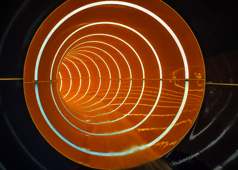 Innenansicht einer gestreiften Röhrenrutsche mit weißen Tageslichtstreifen.