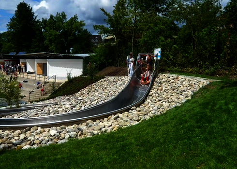 WR1040-Wasserrutsche in naturnaher Umgebung in einem Naturfreibad.