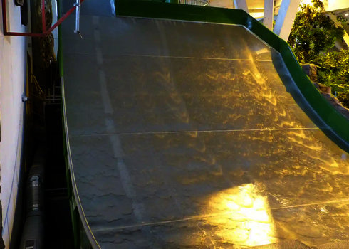 Grüne Sidewinder mit geneigter Fläche und warmem Licht im Hallenbad.