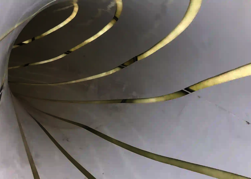 Innenansicht einer weißen Wasserrutsche mit durchsichtigen Streifen.